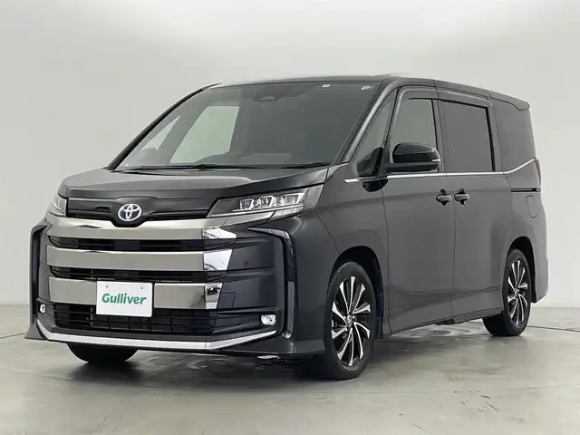 トヨタ ノア ハイブリッド S－Z 群馬県 2022(令4)年 1.8万km アティチュードブラックマイカ ドライビングサポートパッケージ/ ・カラーヘッドアップディスプレイ/ ・デジタルインナーミラー/ユニバーサルステップ(助手席側)/プロジェクター式3眼LEDヘッドランプ/快適利便パッケージ(High)/ ・ハンズフリーデュアルパワースライドドア/ ・パワーバックドア/ ・ナノイーX/ ・ステアリングヒーター/ ・キャプテンシート追加機能(シートヒーター/オットマン)/10.5インチディスプレイオーディオPlus/(AM/FM/Bluetooth/フルセグTV/CD/DVD//USB/HDMI/AppleCarPlay/AndroidAuto)/+ETC2.0ユニット/トヨタチームメイト/ ・アドバンストパーク/ ・パーキングサポートブレーキ/(周囲静止物/後方歩行者+接近車両)/パノラミックビューモニター(床下透過表示機能付)/緊急時操舵支援(アクティブ操舵機能付)/フロントクロストラフィックアラート/レーンチェンジアシスト/エレクトロシフトマチック/ブラインドスポットモニター/安心降車アシスト(ドアオープン制御付)/＝＝＝＝＝/トヨタセーフティセンス/AC100V電源/前後ドライブレコーダー(WHSR-532)/電動パーキングブレーキ/オートブレーキホールド/プッシュスタート