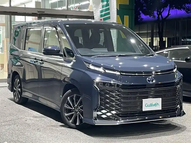 トヨタ ヴォクシー ハイブリッド S－Z 熊本県 2023(令5)年 2.6万km マッシブグレー 衝突軽減ブレーキ/プッシュスタート/純正ナビ/バックカメラ/ビルトインETC/純正フリップダウンモニター（V14T-R72R）/純正17インチAW/両側パワースライドドア/レーダークルーズ/パワーバックドア/ハーフレザーシート/1列目・2列目シートヒーター/LEDヘッドライト/オートライト/前後コーナーセンサー/横滑り防止装置/ウィンカーミラー/純正フロアマット/純正ドアバイザー/新車保証書/取扱説明書/スマートスペアキー×1本