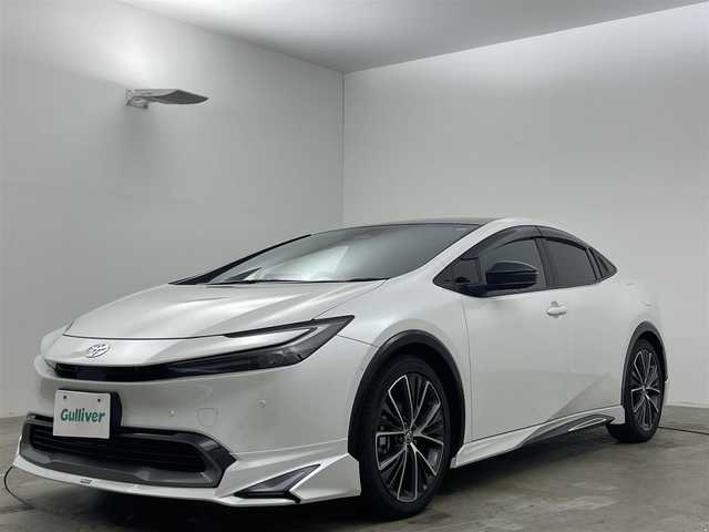 トヨタ プリウス Z 岡山県 2024(令6)年 0.4万km プラチナホワイトパールマイカ パノラマガラスルーフ/モデリスタエアロ（前・横・後下）	/純正１２．３インチディスプレイオーディオ	/【ナビ/フルセグ/Bluetooth/Carplay】	/パノラミックビューモニター	/追従型クルーズコントロール	/オートハイビーム	/LEDヘッドライト（AUTO機能付き）	/ビルトインETC２．０/デジタルインナーミラー/前席シートヒーター	/ステアリングヒーター/前席エアシート/運転席パワーシート	/衝突軽減ブレーキシステム	/車線逸脱防止システム	/横滑り防止装置/踏み間違い防止装置	/ブラインドスポットモニター/オートブレーキホールド/純正ドライブレコーダー（前後）	/純正19インチアルミ	/コーナーセンサー（前後）	/純正フロアマット	/ステアリングスイッチ	/ISOFIX/チルトステアリング/シートリフター/ウィンカーミラー/ドアバイザー/プッシュスタート	/新車保証書/スペアキー×1