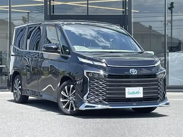 トヨタ ヴォクシー ハイブリッド S－Z 茨城県 2024(令6)年 0.3万km アティチュードブラックマイカ 純正ナビ/【AM・FM・TV・BT・USB】/シートヒーター/100V電源/レーダークルコン/Bカメラ/ETC2.0/前後コーナーセンサー/フロントエアロパーツ/両側パワスラ/ブレーキホールド/オートライト/オートハイビーム/LEDライト/純正フロアマット/純正アルミホイール/横滑り防止装置/レーンキープアシスト/衝突被害軽減システム/ステリモ