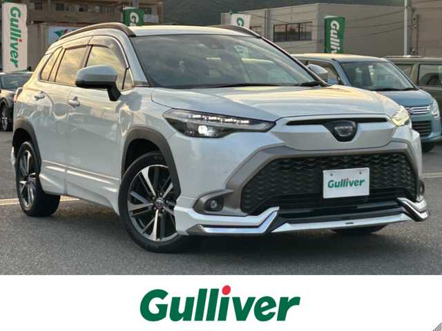 トヨタ カローラ クロス ハイブリッド Z 広島県 2023(令5)年 7万km プラチナホワイトパールマイカ ワンオーナー/純正メモリナビ/　（Bluetooth/フルセグテレビ/AM/FM）/レーダークルーズコントロール/モデリスタエアロ/全方位モニター/ブラインドスポットモニター/電子パーキング/オートブレーキホールド/ビルトインETC/パワーシート/シートヒーター/純正18インチアルミホイール/ルーフレール/純正フロアマット/コーナーセンサー/レーンキープアシスト/横滑り防止装置/衝突被害軽減システム/オートマチックハイビーム/LEDヘッドライト/フォグランプ/カーテンエアバック/スペアキー/保証書/取扱説明書