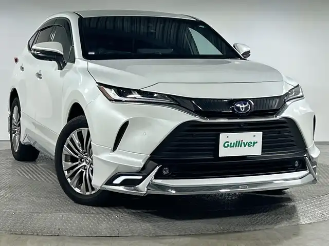 トヨタ ハリアー ハイブリッド Z レザーパッケージ 神奈川県 2023(令5)年 3.4万km プラチナホワイトパールマイカ 12.3型ディスプレイオーディオプラス/JBLプレミアムサウンド/ナビ/フルセグ　Bluetooth　USB/モデリスタエアロ【フロント/サイド/リアアンダー】/マフラー/ヘッドアップディスプレイ/デジタルインナーミラー/パワーバックドア/セーフティセンス/プリクラッシュセーフティ/レーントレーシングアシスト/レーダークルーズコントロール/アダブティブハイビームアシスト/ロードサインアシスト/カーブ速度抑制機能/ドライバー異常時対応システム/横断歩行者検知機能/低速時加速抑制機能/緊急時操舵支援/ブラインドスポットモニター/パーキングサポートブレーキ/先行車発進告知/リヤシートマインダー/後退速度抑制/革巻きステアリング/ステアリングヒーター/革シート/前席パワーシート/シートヒーター/ベンチレーション/運転席ポジションメモリー/前後ソナー/ドライブモード/ETC2.0/電動パーキングブレーキ/AVH/プッシュスタート/スマートキー/純正リアスポイラー/純正19インチアルミホイール/LEDヘッド/フォグランプ
