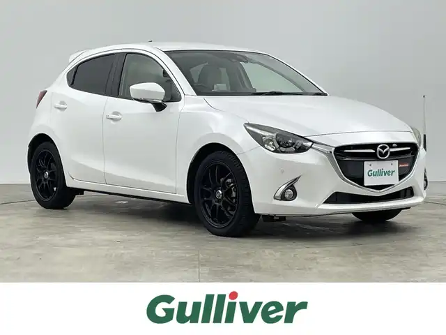 マツダ デミオ 13S Lパッケージ 千葉県 2015(平27)年 1.5万km スノーフレイクホワイトパールマイカ 純正メモリナビ/　CD/DVD/BT/フルセグTV/衝突軽減ブレーキ/レーンキープアシスト/ブラインドスポットモニター/ヘッドアップディスプレイ/ETC/バックカメラ/プッシュスタート&スマートキー/ステアリングスイッチ/革巻きステアリング/HIDヘッドライト/フォグライト/エンケイ17インチアルミホイール