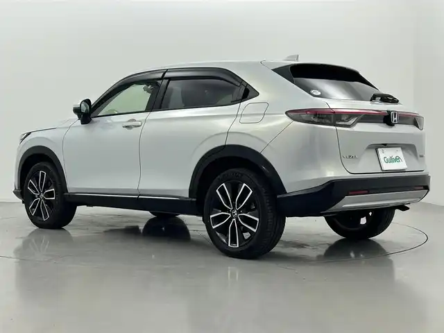 ホンダ ヴェゼル ハイブリッド e:HEV Z 熊本県 2022(令4)年 0.6万km プレミアムサンライトホワイトパール 禁煙車　/純正9インチナビ（ＡｐｐｌＣａｒＰｌａｙ・ＡｎｄｒｏｉｄＡｕｔｏ・フルセグ・ＢＴ・ＵＳＢ）/純正前後ドライブレコーダー　/バックカメラ　/ビルトインＥＴＣ２．０　/前後クリアランスソナー　/ホンダセンシング/・衝突軽減ブレーキ/・前方後方誤発進抑制機能/・近距離衝突軽減ブレーキ/・歩行者事故低減ステアリング/・路外逸脱抑制機能/・渋滞追従機能付きアダブティブクルーズコントロール/・車線維持支援システム/・先行車発進お知らせ/・標識認識システム/・オートハイビーム/・ブラインドスポットモニター/横滑り防止/ダウンヒルアシスト/寒冷地仕様/パワーバックドア/置くだけ充電/ハーフレザーシート/純正フロアマット/純正１８インチAW/オートライト/LEDヘッドライト/フォグライト/スマートキー/プッシュスタート/スペアキー1本/保証書/取扱説明書