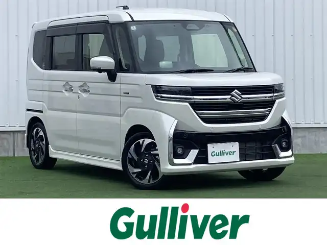 スズキ スペーシア カスタム HYBRID XS 香川県 2024(令6)年 1.2万km ピュアホワイトP 登録時走行距離：11824km/メーカー純正メモリナビ/　CD DVD BT フルセグTV/全方位カメラ/両側パワースライドドア/デュアルセンサーブレーキサポート/レーンキープアシスト/レーダークルーズコントロール/ヘッドアップディスプレイ/クリアランスソナー/LEDヘッドライト/オートライト/フォグランプ/前後ドライブレコーダー/ビルトインETC2.0/ハーフレザーシート/シートヒーター/革巻きステアリング/ステアリングヒーター/電子パーキングブレーキ/後席ロールサンシェード/サーキュレーター/アイドリングストップ/横滑り防止装置/プッシュスタート/スマートキー/スペアキー/新車時保証書/取扱説明書