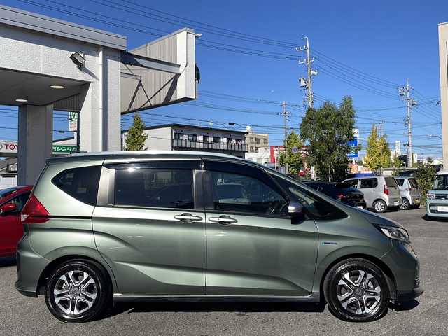 ホンダ フリード ハイブリット クロスター ホンダセンシング 愛知県 2022(令4)年 1.3万km シルバーミストグリーンM /禁煙車//ワンオーナー//純正ナビ【VXM-224VFi】//フルセグTV・DVD・Bluetooth//両側パワースライドドア//LEDヘッドライト+アクティブコーナリングライト//オートライト//CROSSTAR専用装備//ルーフレール//純正15インチアルミホイール//木目調インパネミドルエリア//コンビシート(プライムスムース×ファブリック)//Cパッケージ（ロールサンシェード、IRカット、コンフォートビューパッケージ、D/N席シートヒーター、プラズマクラスター技術搭載フルオートエアコン//HondaSENSING//衝突軽減ブレーキ//先行車発進お知らせ機能//歩行者事故低減ステアリング//路外逸脱抑制機能//アダプティブクルーズコントロール//レーンキープアシスト//誤発進抑制苦悩//後方誤発進抑制機能//電動格納式ウインカーミラー//オートリトラミラー//純正フロアマット//ステアリングスイッチ//ETC//オートライト//スペアキー//新車保証書//取扱説明書