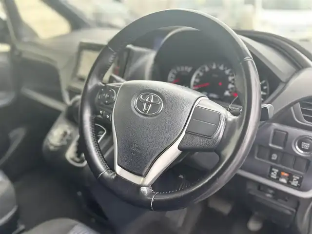 トヨタ ヴォクシー ZS 煌 大分県 2015(平27)年 9.1万km ホワイトパールクリスタルシャイン ・社外メモリーナビ（MDV-Z701W）/　CD/DVD/BT/フルセグ/・ETC/・両側パワースライドドア/・社外フリップダウンモニター/・革巻きステアリング/・スマートキー/・エンジンプッシュスタート/・ウインカーミラー/・ステアリングスイッチ/・フロアマット/・ドアバイザー/・プライバシーガラス/・アイドリングストップ/・横滑り防止システム/・後部座席サンシェード/・純正16インチアルミホイール/・LEDヘッドライト/・純正フォグランプ/・保証書/・取扱説明書