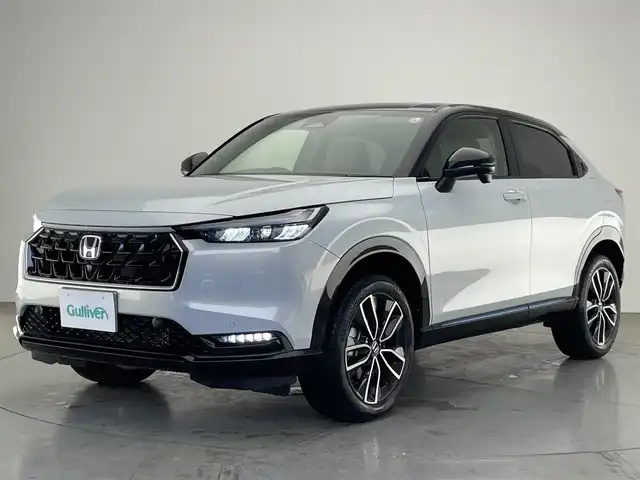 ホンダ ヴェゼル ハイブリッド e:HEV Z PLaYパッケージ 愛知県 2025(令7)年 0.4万km パールⅡ 純正９型ナビ　フルセグＴＶ　カープレイ対応　バックカメラ　白ハーフレザー　シートヒーター　ワイヤレス充電　ホンダセンシング　衝突軽減装置　追従クルコン　ＢＳＭ　ＬＥＤオートライト　フォグランプ　ハンドル支援　ETC2.0　パワーバックドア　ツートンカラー　保証書　ワンオナ　禁煙車/	Honda SENSING/	ブラインドスポットインフォメーション/	アダプティブドライビングビーム(ADB)/	後退出庫サポート/	Honda CONNECTディスプレー＋ETC2.0車載器＋ワイヤレス充電器/	運転席助手席シートヒーター/	ハンズフリーアクセスパワーテールゲート(予約クローズ機能付)/	LEDシーケンシャルターンシグナルランプ/	18インチアルミホイール/	コンビシート(PLaY専用)/	本革巻きステアリング