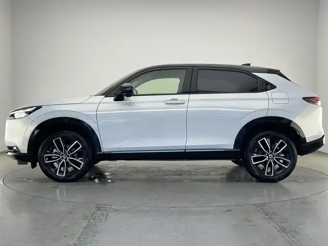 ホンダ ヴェゼル ハイブリッド e:HEV Z PLaYパッケージ 愛知県 2025(令7)年 0.4万km パールⅡ 純正９型ナビ　フルセグＴＶ　カープレイ対応　バックカメラ　白ハーフレザー　シートヒーター　ワイヤレス充電　ホンダセンシング　衝突軽減装置　追従クルコン　ＢＳＭ　ＬＥＤオートライト　フォグランプ　ハンドル支援　ETC2.0　パワーバックドア　ツートンカラー　保証書　ワンオナ　禁煙車/	Honda SENSING/	ブラインドスポットインフォメーション/	アダプティブドライビングビーム(ADB)/	後退出庫サポート/	Honda CONNECTディスプレー＋ETC2.0車載器＋ワイヤレス充電器/	運転席助手席シートヒーター/	ハンズフリーアクセスパワーテールゲート(予約クローズ機能付)/	LEDシーケンシャルターンシグナルランプ/	18インチアルミホイール/	コンビシート(PLaY専用)/	本革巻きステアリング