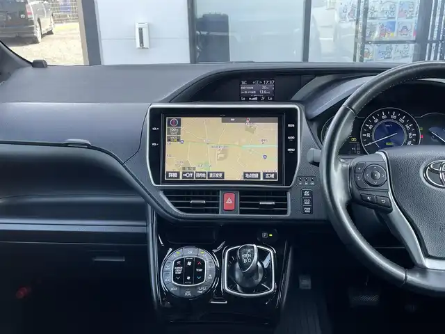トヨタ ヴォクシー ハイブリッド ZS 千葉県 2017(平29)年 6.3万km ブラッキッシュアゲハガラスフレーク 純正10インチナビ/(フルセグTV CD DVD BT FM AM)/デジタルインナーミラー/バックカメラ/衝突被害軽減システム/車線逸脱警報/クルーズコントロール/純正12インチフリップダウンモニター/両側パワースライドドア/横滑り防止装置/ビルトインETC2.0/ドライブレコーダー/アイドリングストップ/LEDヘッドライト/フォグランプ/オートライト/ウィンカーミラー/電動格納ミラー/純正16インチAW/シートヒーター/シートリフター/プッシュスタート/スマートキー/フロアマット/スペアキー/取扱説明書/保証書