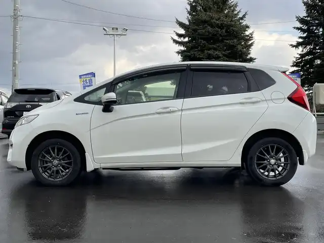 ホンダ フィット ハイブリット Lパッケージ 道北・旭川 2015(平27)年 12.7万km プレミアムホワイトパールⅡ (株)IDOMが運営する【じしゃロン旭川店】の自社ローン対象車両になります。こちらは現金ご利用時の価格です。/自社ローンご希望の方は別途その旨お申付け下さい。/　/・純正ナビ(CD/DVD/フルセグ)/・バックカメラ/・ETC/・レーダーブレーキ/・クルーズコントロール/・ステアリングリモコン/・電動格納ウィンカーミラー/・ミラーヒーター/・プッシュスタート/・スマートキー1個/・オートライト/・現車装着サマータイヤ 社外AW185/60R15