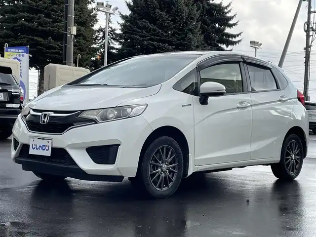 ホンダ フィット ハイブリット Lパッケージ 道北・旭川 2015(平27)年 12.7万km プレミアムホワイトパールⅡ (株)IDOMが運営する【じしゃロン旭川店】の自社ローン対象車両になります。こちらは現金ご利用時の価格です。/自社ローンご希望の方は別途その旨お申付け下さい。/　/・純正ナビ(CD/DVD/フルセグ)/・バックカメラ/・ETC/・レーダーブレーキ/・クルーズコントロール/・ステアリングリモコン/・電動格納ウィンカーミラー/・ミラーヒーター/・プッシュスタート/・スマートキー1個/・オートライト/・現車装着サマータイヤ 社外AW185/60R15