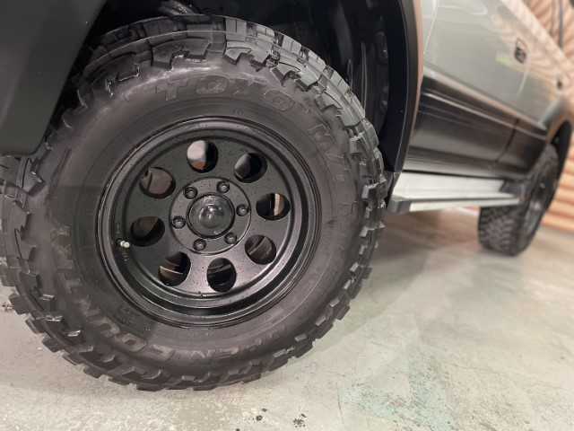 トヨタ ランドクルーザー プラド TX ワイド 千葉県 2000(平12)年 7.8万km シルバーM/シルバーM AIS検査済み/【2410006203】/4WD(フル）/ルーフレール/フロントフォグランプ/純正フロアマット/純正サンルーフ/3列シート（8人乗り）/キーレス/パワーウィンドウ/ETC(通常）/パワステ/AAC/盗難防止装置/ABS/ヘッドレスト/16AW  ミッキートンプソン MT-058（社外）/トーヨー オープンカントリーM/T（社外）/リフトアップ（社外）/TOYOTAロゴグリル（社外）/千鳥シートカバー（社外）/社外パーツ取り付けあり