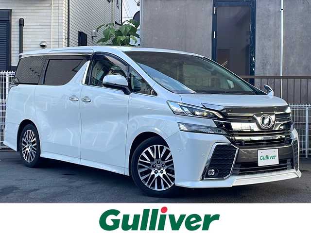 トヨタ ヴェルファイア Z Gエディション 京都府 2015(平27)年 9.1万km ホワイトパールクリスタルシャイン 純正SDナビ/(フルセグ/CD／DVD／BT／USB／AUX)/JBLサウンド/Wサンルーフ/フリップダウンモニター/バックカメラ/両側パワースライドドア/電動リアゲート/電子パーキング/ブレーキホールド/クルーズコントロール/オットマン（N席・二列目）/LEDヘッドライト/ハーフレザーシート/パワーシート（D/N席）/純正18インチアルミホイール/アイドリングストップ/前後コーナーセンサー/MTモード付AT/前方ドライブレコーダー/スマートキー/ETC