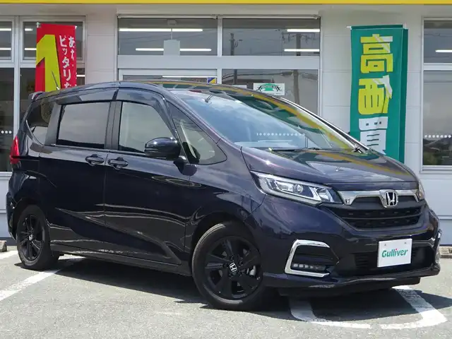 ホンダ フリード G ブラックスタイル 静岡県 2023(令5)年 1.8万km トワイライトミストブラックパール ワンオーナー/禁煙車/両側パワースライドドア/・ホンダセンシング/・シートヒーター（運転席、助手席）/・歩行者事故低減ステアリング/・衝突軽減ブレーキ/・アダプティブクルーズコントロール/・車線維持支援システム/・路外逸脱抑制機能/・誤発進抑制機能（前方、後方）/・先行車発進お知らせ機能/・標識認識機能/・マルチインフォメーションシステム/純正Gathers VXM-225VFEi/（CD/DVD/SD/ipod/BT/フルセグTV/USB）木目調ウッドパネル/2列目キャプランシート/2列目ロールサンシェード/プッシュスタート/スマートキー×2個/LEDヘッドライト/オートライト/ステアリングリモコン/バックカメラ/Yupiteru前後ドライブレコーダー/ビルトインETC/ハンドルカバー/純正フロアマット/バイザー/保証書、取扱説明書