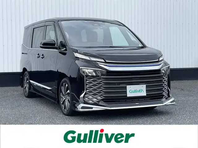 トヨタ ヴォクシー ハイブリッド S－Z 千葉県 2022(令4)年 2.1万km アティチュードブラックマイカ 純正8インチディスプレイオーディオ/(BT FM AM)/モデリスタエアロ/前後ドライブレコーダー/バックカメラ/衝突被害軽減システム/車線逸脱警報/クルーズコントロール/ハーフレザーシート/両側パワースライドドア/横滑り防止装置/ビルトインETC2.0/アイドリングストップ/LEDヘッドライト/フォグランプ/オートライト/ウィンカーミラー/電動格納ミラー/純正17インチAW/シートヒーター/シートリフター/プッシュスタート/スマートキー/フロアマット/ドアバイザー/保証書