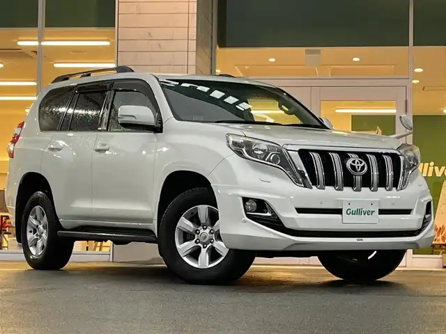 トヨタ ランドクルーザー プラド TX Lパッケージ 兵庫県 2015(平27)年 13万km ホワイトパールクリスタルシャイン モデリスタエアロ/サンルーフ/DN席シートヒーター/３列目電動シート/クルーズコントロール/ビルトインETC/純正アルミホイール/Bluetooth接続/ダウンヒルアシストコントロール/４WD/社外メモリナビ/オートマチックハイビーム/ヘッドライトウォッシャー/フルセグTV/スペアキー/スイッチスタート