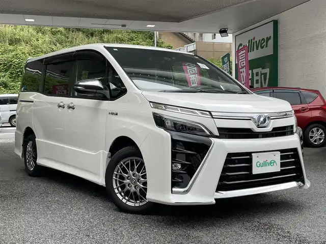 トヨタ ヴォクシー ハイブリッド ZS 煌Ⅱ 神奈川県 2019(平31)年 2.5万km ホワイトパールクリスタルシャイン 登録時走行距離24427km/ワンオーナー/純正HDDナビ/　【CD/フルセグTV】/バックカメラ/クルーズコントロール(追従走行なし)/衝突被害軽減ブレーキ/横滑り防止/両側パワースライドドア/シートヒーター/コーナーセンサー/ビルトインETC/オートライト/純正LEDライト/フォグランプ/スマートキー/プッシュスタート/純正アルミホイール 16インチ/ドアバイザー/ウインカーミラー/純正フロアマット/リアプライバシーガラス/スペアキー×1【スマートキー】/新車時整備手帳（保証書）/取扱説明書