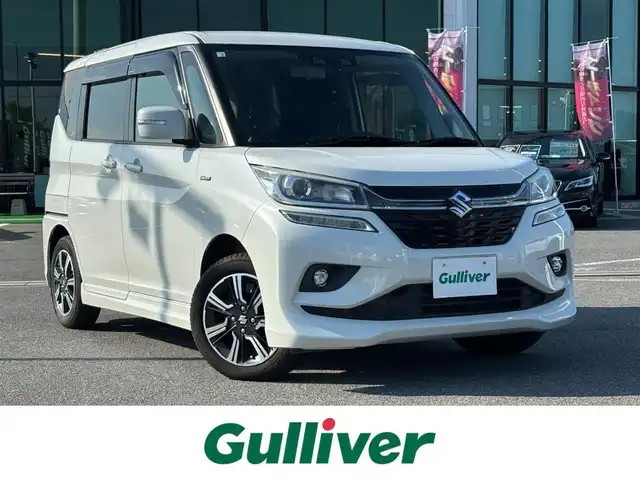 スズキ ソリオ バンディット HV MV 奈良県 2018(平30)年 6.5万km ピュアホワイトP 両側パワースライドドア/社外ナビ(フルセグTV/CD/DVD/AM・FM/BT/iPod)/バックカメラ/ETC/スズキセーフティサポート/誤発進抑制機能/車線逸脱警報機能/先行車発進お知らせ機能/クルーズコントロール/パドルシフト/運転席シートヒーター/本革巻きステアリング/LEDヘッドライト/純正15インチアルミホイール/純正フロアマット/後席サンシェード/スペアキー