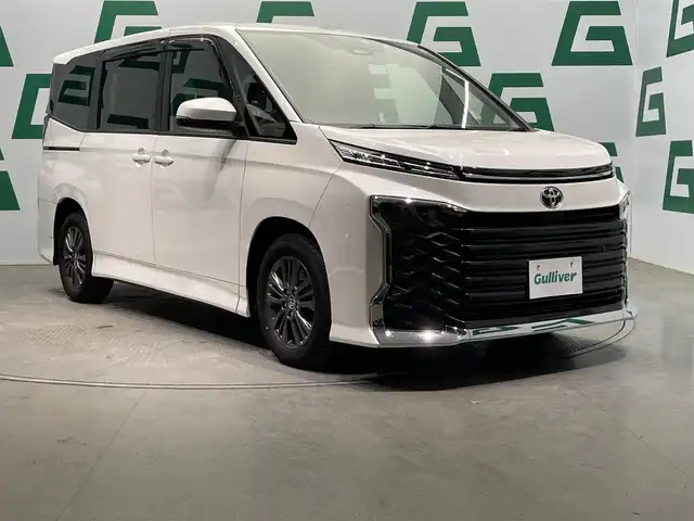 トヨタ ヴォクシー S－G 鹿児島県 2023(令5)年 1.2万km ホワイトパールクリスタルシャイン 禁煙車/10.5インチ純正ディスプレイオーディオ/　・フルセグTV/Bluetooth/トヨタセーフティセンス/　・プリクラッシュセーフティー/　・緊急時操蛇支援/　・レーントレーシングアシスト/　・レーダークルーズコントロール/　・オートマチックハイビーム/　・ロードサインアシスト/　・ドライバー異常時対応システム/　・発信遅れ告知機能/両側パワースライド/電動パーキングブレーキ/ブレーキホールド/純正フロアマット/前後ドライブレコーダー/全席オートウィンドウ/ドアバイザー/ETC/後席サンシェード/本革巻きハンドル