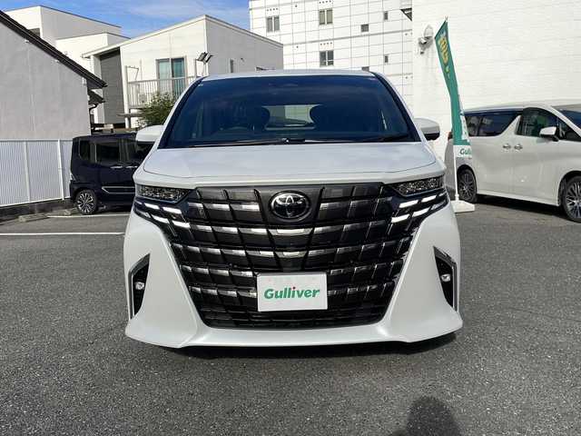 トヨタ アルファードハイブリット Z 愛知県 2025(令7)年 0.1千km プラチナホワイトパールマイカ ワンオーナー/14インチディスプレイオーディオプラス/【コネクティッドナビ対応・フルセグTV・AM/FM・USB入力・HDMI入力・AppleCarPlay・AndrodiAuto】/ETC2.0/左右独立ムーンルーフ/デジタルインナーミラー/パワーシート（前席）/・マイコンプリセットドライビングポジションシステム/助手席肩口パワーシートスイッチ/2列目エグゼクティブパワーシート/【パワーリクライニング・大型ヘッドレスト・快適温熱シート・充電用USB端子・パワーオットマン・折り畳み式サイドテーブル・大型アームレスト】/セーフティセンス（予防安全パッケージ）/【プリクラッシュセーフティ・レーントレーシングアシスト・レーンディパーチャーアラート・全車速追従機能付レーダークルーズコントロール・アダプティブハイビームシステム・ロードサインアシスト】/トヨタチームメイト/カラーヘッドアップディスプレイ/・タッチトレーサーオペレーション/ユニバーサルステップ/グローブボックス照明/おくだけ充電/床下透過表示機能付パノラミックビューモニター/3眼LEDヘッドライトランプ/新車保証書/スペアキー