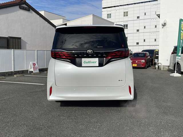 トヨタ アルファードハイブリット Z 愛知県 2025(令7)年 0.1千km プラチナホワイトパールマイカ ワンオーナー/14インチディスプレイオーディオプラス/【コネクティッドナビ対応・フルセグTV・AM/FM・USB入力・HDMI入力・AppleCarPlay・AndrodiAuto】/ETC2.0/左右独立ムーンルーフ/デジタルインナーミラー/パワーシート（前席）/・マイコンプリセットドライビングポジションシステム/助手席肩口パワーシートスイッチ/2列目エグゼクティブパワーシート/【パワーリクライニング・大型ヘッドレスト・快適温熱シート・充電用USB端子・パワーオットマン・折り畳み式サイドテーブル・大型アームレスト】/セーフティセンス（予防安全パッケージ）/【プリクラッシュセーフティ・レーントレーシングアシスト・レーンディパーチャーアラート・全車速追従機能付レーダークルーズコントロール・アダプティブハイビームシステム・ロードサインアシスト】/トヨタチームメイト/カラーヘッドアップディスプレイ/・タッチトレーサーオペレーション/ユニバーサルステップ/グローブボックス照明/おくだけ充電/床下透過表示機能付パノラミックビューモニター/3眼LEDヘッドライトランプ/新車保証書/スペアキー