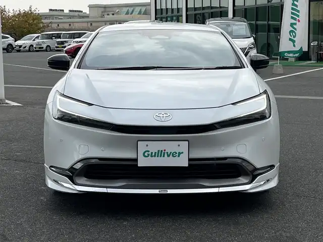 トヨタ プリウス Z 奈良県 2025(令7)年 1.3万km プラチナホワイトパールマイカ モデリスタエアロ/純正12インチディスプレイオーディオ/（TV/BT/AppleCarPlay/AndroidAuto）/レーダークルーズコントロール/アラウンドビューモニター/ブラインドスポットモニター/前後コーナーセンサー/プリクラッシュセーフティ/レーンキープアシスト/パーキングアシスト/パワーバックドア/レザーシート/運転席メモリ付きパワーシート/前席シートヒーター/エアーシート/ステアリングヒーター/ワイヤレス充電/デジタルインナーミラー/LEDヘッドライト/ETC2.0/純正19インチAW/保証書/取り扱い説明書