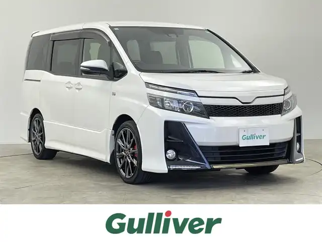 トヨタ ヴォクシー ZS G’s 千葉県 2016(平28)年 7.7万km ホワイトパールクリスタルシャイン ワンオーナー/禁煙車/トヨタセーフティセンス/・先行車発進システム/・レーンディパーチャーアラート/両側電動ドア/アルパインフリップダウンモニター/アルパイン11インチナビ/・型番：EX11V/・CD/DVD/Bluetooth/フルセグTV/・バックカメラ/・ビルトインETC/・デジタルインナーミラー/MT付きAT/革巻きステアリング/・ステアリングスイッチ/左右独立エアコン/ハーフレザーシート/純正フロアマット/純正ドアバイザー/社外18インチAW/オートライト/・LEDヘッドライト/・フォグランプ/プッシュスタート/・スマートキー/・スペアキー