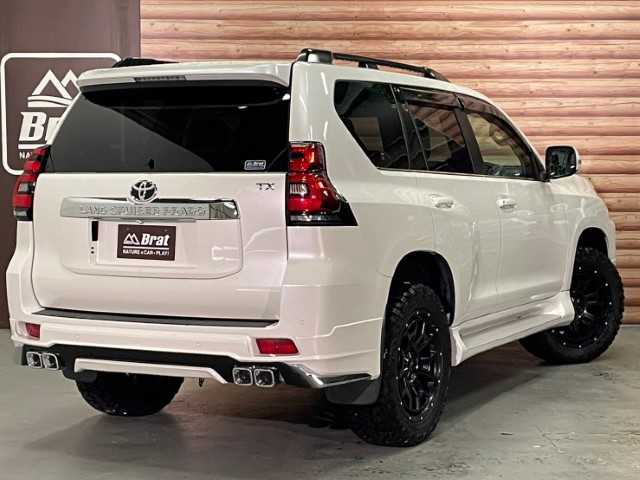 トヨタ ランドクルーザー プラド TX Lパッケージ 道北・旭川 2017(平29)年 2.5万km ホワイトパールクリスタルシャイン 【2405032058】/アルパイン9インチナビ（社外）/クルーズコントロール/前席シートヒーター/ベンチレーター/ETC/オートハイビーム/ヘッドライトウォッシャー/センターデフロック/コーナーセンサー/純正フロアマット/純正ドアバイザー/7人乗り/20AW ナイトロパワー  H6スラッグ（社外）/レーダー　レネゲードR/T＋（社外）/ボンネットエンブレム/社外パーツ取り付けあり。