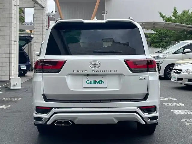 トヨタ ランドクルーザー ZX 東京都 2023(令5)年 1.5万km プレシャスホワイトパール 純正メモリーナビ/　フルセグTV　BT　CD/DVD　AM/FM　USB/　SD　HDMI/AppleCatPlay/AndoroidAuto/パワーバックドア/全方位カメラ/電動サンルーフ/ETC2.0/前後ドライブレコーダー/トヨタセーフティセンス/木目調革巻きステアリング/　ステアリングヒーター/ベージュ本革シート/　前席パワーシート/　前席/2列目ベンチレーション付快適温熱シート/　3列目電動格納シート/モデリスタエアロ/純正20インチアルミホイール/JBLサウンドシステム/100V電源/クールボックス/盗難防止装置Panthera/リアシートエンターテインメントシステム/左右後席独立温度調整オートエアコン/レーザークルーズコントロール/ルーフレール/保証書＆取扱説明書