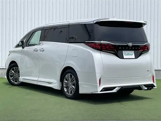 トヨタ アルファードハイブリット Z 香川県 2023(令5)年 1.6万km プラチナホワイトパールマイカ 登録時走行距離：15393km/メーカー純正ナビ/　BT フルセグTV/全方位カメラ/フリップダウンモニター/モデリスタエアロ/左右独立稼働型ムーンルーフ/ブラックレザーシート/シートベンチレーション/パワーシート/シートメモリ/オットマン/電動シェード/プリクラッシュセーフティシステム/レーンキープアシスト/レーダークルーズコントロール/クリアランスソナー/ブラインドスポットモニター/ヘッドアップディスプレイ/オートハイビーム/LEDヘッドライト/オートライト/フォグランプ/前後ドライブレコーダー/ビルトインETC2.0/MTモード付AT/横滑り防止装置/オートホールド機能付き電子パーキングブレーキ/置くだけ充電/AC100V充電/木目革巻きコンビステアリング/ステアリングスイッチ/ステアリングヒーター/プッシュスタート/スマートキー