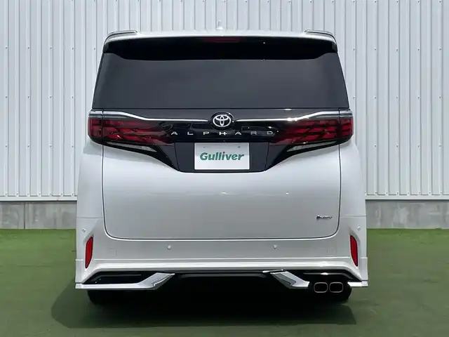 トヨタ アルファードハイブリット Z 香川県 2023(令5)年 1.6万km プラチナホワイトパールマイカ 登録時走行距離：15393km/メーカー純正ナビ/　BT フルセグTV/全方位カメラ/フリップダウンモニター/モデリスタエアロ/左右独立稼働型ムーンルーフ/ブラックレザーシート/シートベンチレーション/パワーシート/シートメモリ/オットマン/電動シェード/プリクラッシュセーフティシステム/レーンキープアシスト/レーダークルーズコントロール/クリアランスソナー/ブラインドスポットモニター/ヘッドアップディスプレイ/オートハイビーム/LEDヘッドライト/オートライト/フォグランプ/前後ドライブレコーダー/ビルトインETC2.0/MTモード付AT/横滑り防止装置/オートホールド機能付き電子パーキングブレーキ/置くだけ充電/AC100V充電/木目革巻きコンビステアリング/ステアリングスイッチ/ステアリングヒーター/プッシュスタート/スマートキー