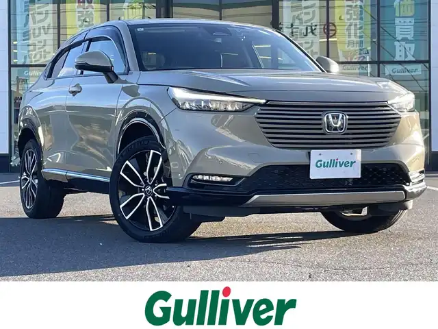 ホンダ ヴェゼル ハイブリッド e:HEV Z 岡山県 2021(令3)年 4.1万km サンドカーキパール 登録時走行距離40180km/純正ナビ/フルセグTV（AM/FM/CD/DVD/Bluetooth）/バックカメラ/ビルトインETC/ドライブレコーダー/パワーバックドア/ホンダセンシング/・ブラインドスポットモニター/・衝突軽減ブレーキ/・アダプティブクルーズコントロール/・クリアランスソナー/・パーキングサポートブレーキ/・標識認識システム/・ヒルディセントコントロール/ハーフレザーシート/D/N席シートヒーター/純正18インチアルミホイール/LEDヘッドライト/スマートキー×2