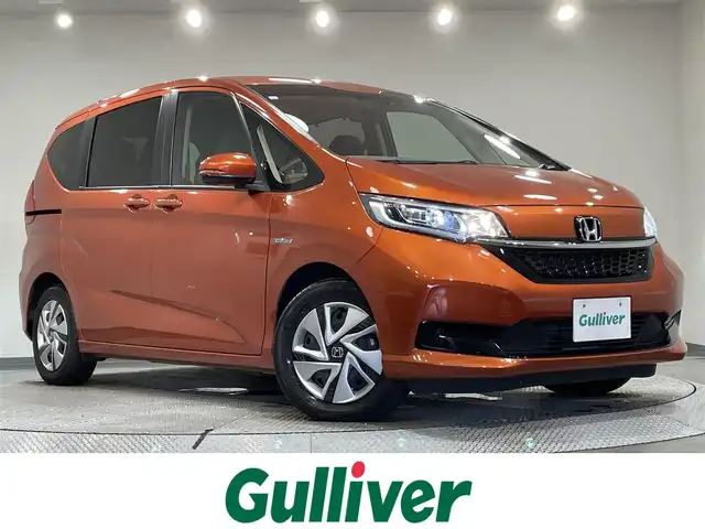 ホンダ フリード ハイブリット G ホンダセンシング 愛知県 2020(令2)年 4.7万km プレミアムクリスタルオレンジM KENWOOD7インチナビ/（Bluetooth/AM/FM/フルセグTV）/衝突軽減ブレーキ/両側電動スライドドア/レーダークルーズコントロール/シートヒーター/LEDヘッドライト/ETC/バックカメラ/コーナーセンサー/レーンキープアシスト/プッシュスタートボタン/スマートキー/純正15インチAW/社外ホイール付きスタッドレス