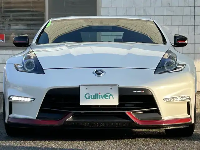 日産 フェアレディ Ｚ ニスモ 福岡県 2019(平31)年 2.3万km ブリリアントホワイトパール NISUMO専用装備/・フロントバンパー/・LEDハイパーディライト/・サイドシルプロテクター/・リアバンパー/・リアスポイラー/・マフラー/・レイズ製19インチAW/・RECARO製スポーツシート/・コンビメーター/・アルカンターラ巻3本スポークステアリング/・YAMAHA製パフォーマンスダンパー（フロント・リア）/・フロアマット/エンジンチューニング/純正赤色キャリパー/BOSEプレミアムサウンド/純正HDDナビ/　（AM/FM/CD/DVD/Bluetooth/フルセグTV）/バックカメラ/横滑り防止装置/パドルシフト/ASSURA製レーダー探知機【AR-333RA】/KENWOOD製前方ドライブレコーダー【DRV-MR740】/ビルトインETC/電格ウインカーミラー/電源ソケット×1/USB端子×1/スペアキー×1/保証書/エンジンチューニング保証書/取扱説明書/ナビ取扱説明書