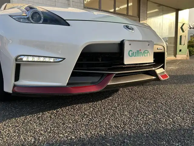 日産 フェアレディ Ｚ ニスモ 福岡県 2019(平31)年 2.3万km ブリリアントホワイトパール NISUMO専用装備/・フロントバンパー/・LEDハイパーディライト/・サイドシルプロテクター/・リアバンパー/・リアスポイラー/・マフラー/・レイズ製19インチAW/・RECARO製スポーツシート/・コンビメーター/・アルカンターラ巻3本スポークステアリング/・YAMAHA製パフォーマンスダンパー（フロント・リア）/・フロアマット/エンジンチューニング/純正赤色キャリパー/BOSEプレミアムサウンド/純正HDDナビ/　（AM/FM/CD/DVD/Bluetooth/フルセグTV）/バックカメラ/横滑り防止装置/パドルシフト/ASSURA製レーダー探知機【AR-333RA】/KENWOOD製前方ドライブレコーダー【DRV-MR740】/ビルトインETC/電格ウインカーミラー/電源ソケット×1/USB端子×1/スペアキー×1/保証書/エンジンチューニング保証書/取扱説明書/ナビ取扱説明書