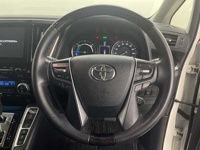 トヨタ ヴェルファイア ハイブリット 道央・札幌 2015(平27)年 5.1万km ホワイトパールクリスタルシャイン ・4WD/・JBLサウンドナビ/（CD DVD SD BT USB フルセグ）/・モデリスタエアロ（F S R）/・モデリスタマフラーカッター/・トヨタセーフティセンス/・純正フリップダウン/・両側パワースライドドア/・クルーズコントロール/・クリアランスソナー/・社外ワイヤレス充電/・パーキングアシスト/・LEDヘッドライト/・オートマチックハイビーム/・ハーフレザーシート