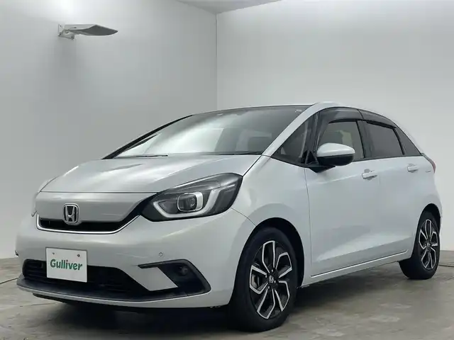 ホンダ フィット e:HEVホーム 岡山県 2020(令2)年 1.5万km プレミアムサンライトホワイトパール 純正９インチナビ/【Bluetooth/フルセグTV/USB】/純正16インチAW(オプション）/ハーフレザーシート/衝突軽減ブレーキ/追従型クルーズコントロール/ビルトインＥＴＣ/ＬＥＤヘッドライト＆LEDフォグランプ/オートハイビーム　/純正ドライブレコーダー（前後）/バックカメラ/純正フロアマット/踏み間違い防止/オートブレーキホールド/ISOFIX/ステアリングスイッチ/チルトステアリング/シートリフター/ウインカーミラー/ドアバイザー/プッシュスタート/スマートキー×2/保証書/取扱説明書/ナビ取扱説明書