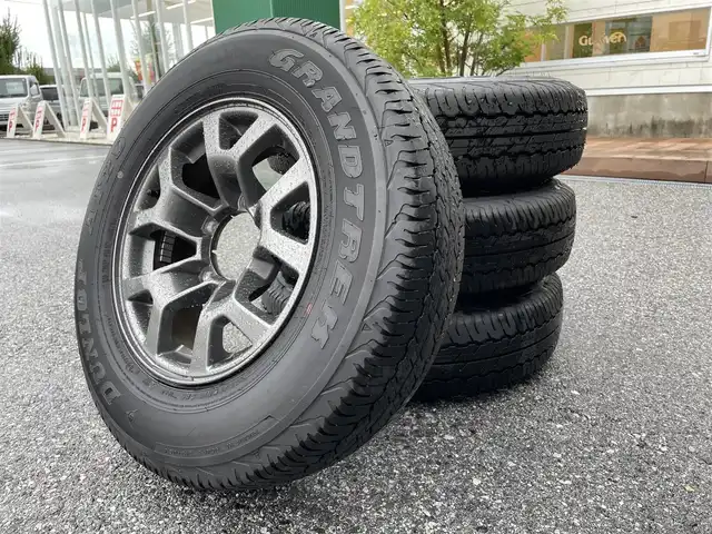 スズキ ジムニー シエラ JC 滋賀県 2023(令5)年 1.2万km ミディアムグレー ５MT/社外ルーフラック/社外ハイマウントストップランプ/社外ボンネットガード/社外リアラダー/積込夏タイヤ/６．８インチディスプレイオーディオ/（FM/AM/CD/iPod）/バックカメラ/前後ドライブレコーダー/ETC/衝突軽減ブレーキ/横滑り防止装置/レーンキープアシスト/ダウンヒルコントロール/運転席・助手席シートヒーター/運転席・助手席ドリンクホルダー/電動格納ミラー/アイドリングストップ/ステアリングスイッチ/オートライト/LEDヘッドライト/フロントフォグ/ヘッドライトウォッシャー/フルオートエアコン/ミラーヒーター/拡張シガーソケット/プッシュスタート/スマートキー/スペアキー/純正ドアバイザー