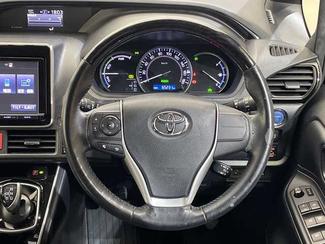 トヨタ エスクァイア ハイブリッド Gi 愛媛県 2015(平27)年 6.6万km ブラック 純正フリップダウンモニター/純正９型ナビ/フルセグTV　Bluetooth　DVD再生/バックカメラ/クルーズコントロール/両側電動スライドドア/レザーシート/クルーズコントロール/ドライブレコーダー/ＥＴＣ/おくだけ充電/シートヒーター/ＬＥＤ