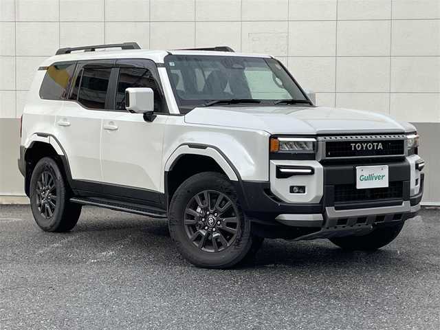 トヨタ ランドクルーザー ２５０ VX 東京都 2025(令7)年 0.5万km プラチナホワイトパールマイカ ワンオーナー/モデリスタインテリアイルミネーション/モデリスタシグネチャーイルミブレード/モデリスタフロントアンダーカバー/モデリスタフロントバンパーガード/モデリスタリヤバンパーガーニッシュ/モデリスタオーバーフェンダー/レインクリアリングブルーミラー/ムーンルーフ/純正12.3インチディスプレイオーディオ/パノラミックビューモニター/デジタルインナーミラー/ブラック革シート/パワーシート/ベンチレーション/パワーバックドア/LEDヘッドライト/LEDフォグランプ/プリクラッシュセーフティ/レーントレーシングアシスト/レーンディパーチャーアラート/レーダークルーズコントロール/オートマチックハイビーム/ロードサインアシスト/ブラインドスポットモニター/前後ドライブレコーダー/純正18インチアルミホイール/ビルトインETC2.0/ステアリングヒーター/ステアリングスイッチ/革巻きステアリングホイール/プッシュスタート/スマートキー/スペアキー/電動オート格納ミラー/LEDウインカーミラー/保証書