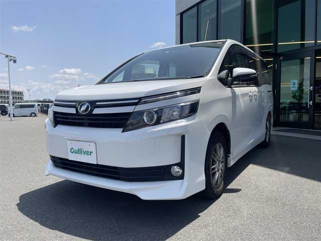 トヨタ ヴォクシー V 東京都 2014(平26)年 7.7万km ホワイトパールクリスタルシャイン 純正メモリナビ〔NSZT-W62G〕/BT/CD/DVD/フルセグTV/バックカメラ/片側パワースライドドア/クルーズコントロール/ビルトインETC/ドライブレコーダー/トヨタセーフティセンスC/　・プリクラッシュセーフティシステム/　・レーンディパーチャーアラート/　・オートマチックハイビーム/LEDオートライト/純正15インチアルミホイール/純正フロアマット/後席ロールサンシェード/MTモード付AT/フォグランプ/純正１６インチホイール付きサマータイヤ車載/プッシュスタート/スマートキー/保証書/整備記録簿/取扱説明書