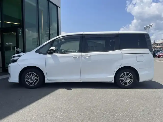 トヨタ ヴォクシー V 東京都 2014(平26)年 7.7万km ホワイトパールクリスタルシャイン 純正メモリナビ〔NSZT-W62G〕/BT/CD/DVD/フルセグTV/バックカメラ/片側パワースライドドア/クルーズコントロール/ビルトインETC/ドライブレコーダー/トヨタセーフティセンスC/　・プリクラッシュセーフティシステム/　・レーンディパーチャーアラート/　・オートマチックハイビーム/LEDオートライト/純正15インチアルミホイール/純正フロアマット/後席ロールサンシェード/MTモード付AT/フォグランプ/純正１６インチホイール付きサマータイヤ車載/プッシュスタート/スマートキー/保証書/整備記録簿/取扱説明書