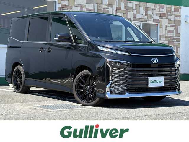 トヨタ ヴォクシー ハイブリッド S－Z 徳島県 2024(令6)年 0.7万km グリッターブラックガラスフレーク 純正10.5インチディスプレイオーディオ/（ナビ/Bluetooth/フルセグTV/HDMI/CD/DVD）/アラウンドビューモニター/両側パワースライドドア/アドバンストパーク/レーダークルーズコントロール/レーンディパーチャーアラート/ブラインドスポットモニター/プリクラッシュセーフティ/クリアランスソナー/シートヒーター（1.2列目）/パワーバックドア/Wエアコン/LEDヘッドライト/ルームミラーーモニター/ETC2.0