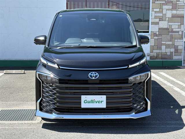 トヨタ ヴォクシー ハイブリッド S－Z 徳島県 2024(令6)年 0.7万km グリッターブラックガラスフレーク 純正10.5インチディスプレイオーディオ/（ナビ/Bluetooth/フルセグTV/HDMI/CD/DVD）/アラウンドビューモニター/両側パワースライドドア/アドバンストパーク/レーダークルーズコントロール/レーンディパーチャーアラート/ブラインドスポットモニター/プリクラッシュセーフティ/クリアランスソナー/シートヒーター（1.2列目）/パワーバックドア/Wエアコン/LEDヘッドライト/ルームミラーーモニター/ETC2.0