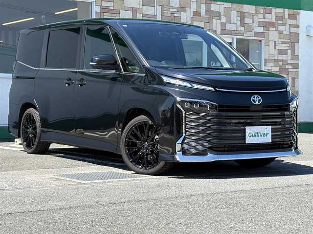 トヨタ ヴォクシー ハイブリッド S－Z 徳島県 2024(令6)年 0.7万km グリッターブラックガラスフレーク 純正10.5インチディスプレイオーディオ/（ナビ/Bluetooth/フルセグTV/HDMI/CD/DVD）/アラウンドビューモニター/両側パワースライドドア/アドバンストパーク/レーダークルーズコントロール/レーンディパーチャーアラート/ブラインドスポットモニター/プリクラッシュセーフティ/クリアランスソナー/シートヒーター（1.2列目）/パワーバックドア/Wエアコン/LEDヘッドライト/ルームミラーーモニター/ETC2.0