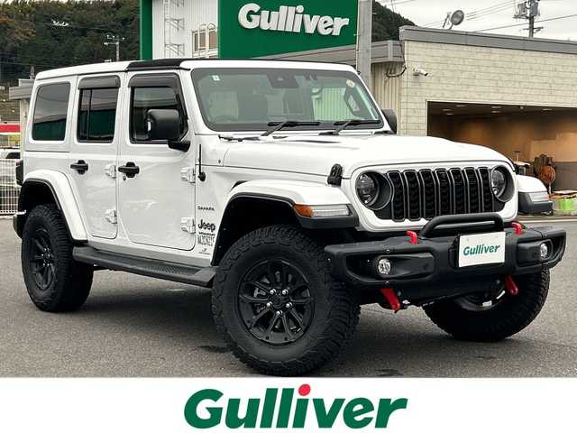 クライスラー・ジープ ジープ ラングラー アンリミテッド サハラ 山口県 2024(令6)年 2.5万km 白 ワンオーナー車/純正ナビ/Bluetooth/フルセグTV/バックカメラ/LEDヘッドライト/LEDフォグライト/オートライト/コーナーセンサー/スマートキー＆プッシュスタート/クルーズコントロール/黒レザーシート/前席シートヒーター/ステアリングヒーター/社外バンパー（純正あり）/社外マフラー（純正あり）/社外17インチAW（純正18インチAWあり）/社外グリル（純正あり）/保証書/スペアキー1個