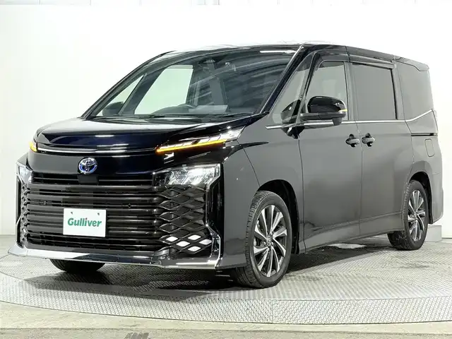 トヨタ ヴォクシー ハイブリッド S－Z 大阪府 2024(令6)年 2.5万km アティチュードブラックマイカ 快適利便パッケージ 純正10.5incナビTV バックカメラ フリップダウンモニター ハーフレザー シート＆ハンドルヒーター オットマン 電動リアゲート レーダーC 衝突軽減ブレーキ レーンアシスト 前後ドライブレコーダー