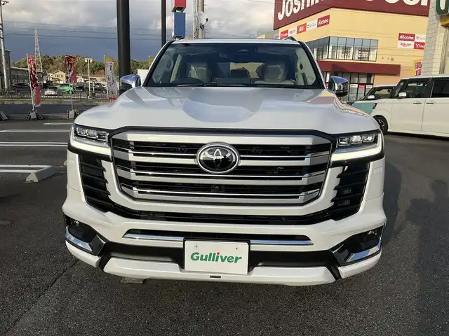 トヨタ ランドクルーザー ZX 滋賀県 2025(令7)年 0.1千km プレシャスホワイトパール ワンオーナー/車検10年9月まで/モデリスタエアロ（フロント、サイド、リア）/3列シート7人乗り/ブラックルーフレール/クールボックス/トノカバー/ムーンルーフ/タイヤ空気圧警報システム/トヨタセーフティセンス/ブラインドスポットモニター/レーダークルーズコントロール/12.3インチディスプレイオーディオプラス/フルセグテレビ、AppleCarPlay、AndroidAuto/JBLプレミアムサウンドシステム/後席11.6インチリアシートエンターテインメント/パノラミックビューモニター/ビルトインETC2.0/ベージュ革シート/前席パワーシート/前席、2列目ベンチレーション付き快適温熱シート/スペアキー有り/取扱説明書、保証書/