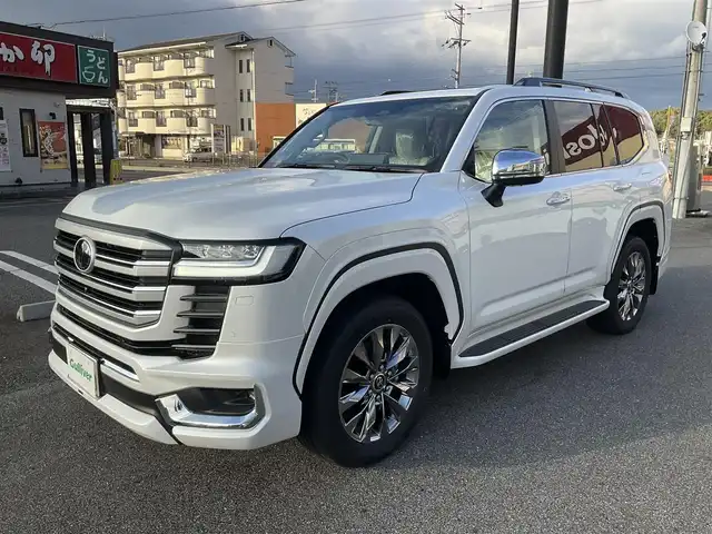 トヨタ ランドクルーザー ZX 滋賀県 2025(令7)年 0.1千km プレシャスホワイトパール ワンオーナー/車検10年9月まで/モデリスタエアロ（フロント、サイド、リア）/3列シート7人乗り/ブラックルーフレール/クールボックス/トノカバー/ムーンルーフ/タイヤ空気圧警報システム/トヨタセーフティセンス/ブラインドスポットモニター/レーダークルーズコントロール/12.3インチディスプレイオーディオプラス/フルセグテレビ、AppleCarPlay、AndroidAuto/JBLプレミアムサウンドシステム/後席11.6インチリアシートエンターテインメント/パノラミックビューモニター/ビルトインETC2.0/ベージュ革シート/前席パワーシート/前席、2列目ベンチレーション付き快適温熱シート/スペアキー有り/取扱説明書、保証書/